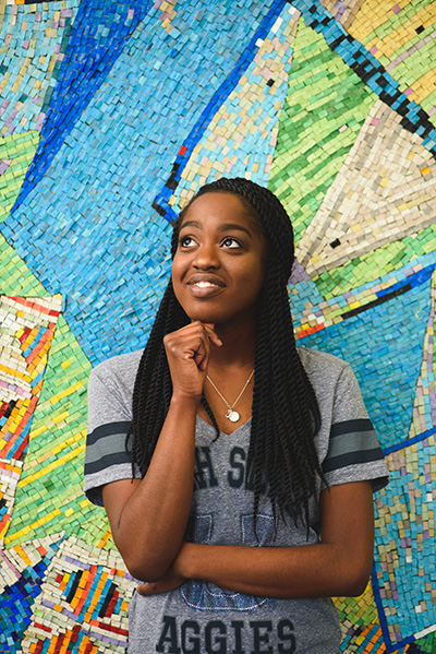Student standing in front of a colorful backdrop