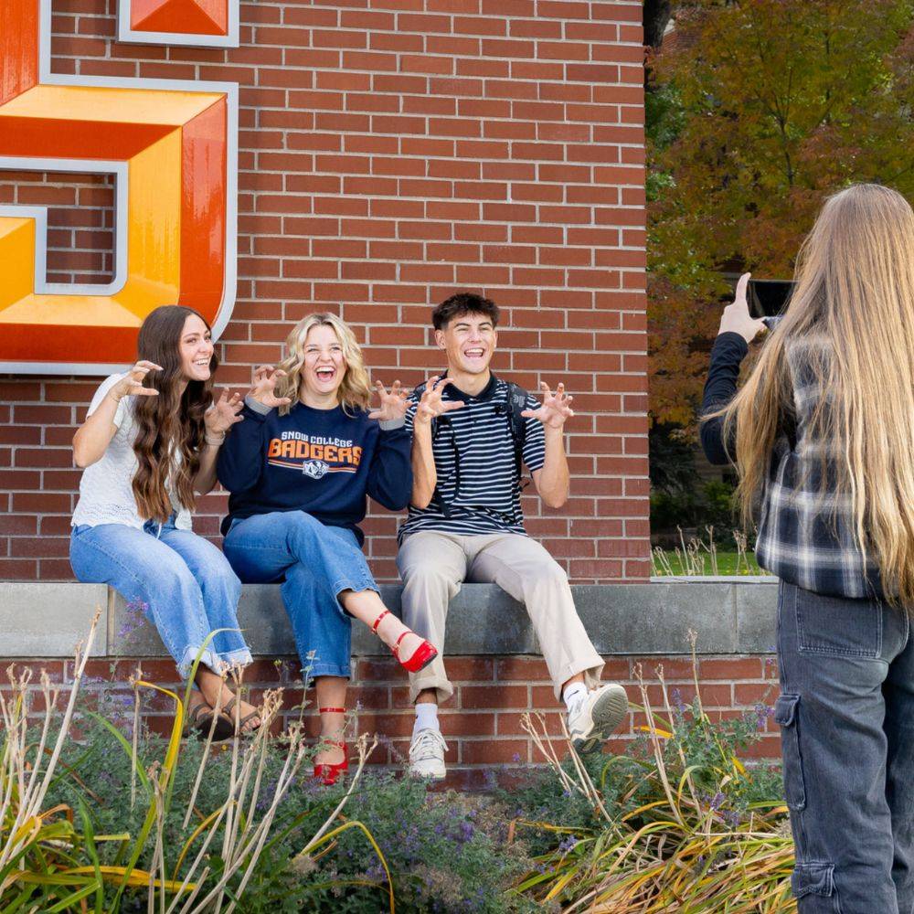 Students at Snow College posing in front of the 'S' on campus.