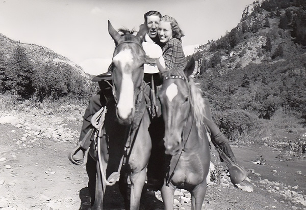 Black and white photo of Marion and Opal Chugg embracing each other on horses