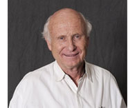 Portrait of Bill Furlong wearing a white shirt with a gray background