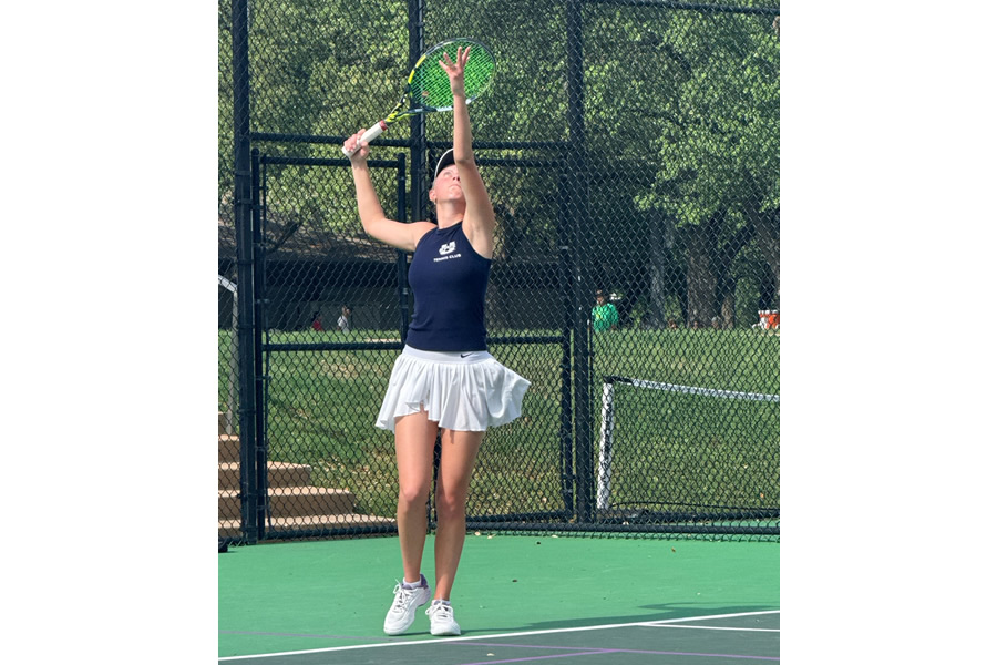 Girl serving tennis ball on court