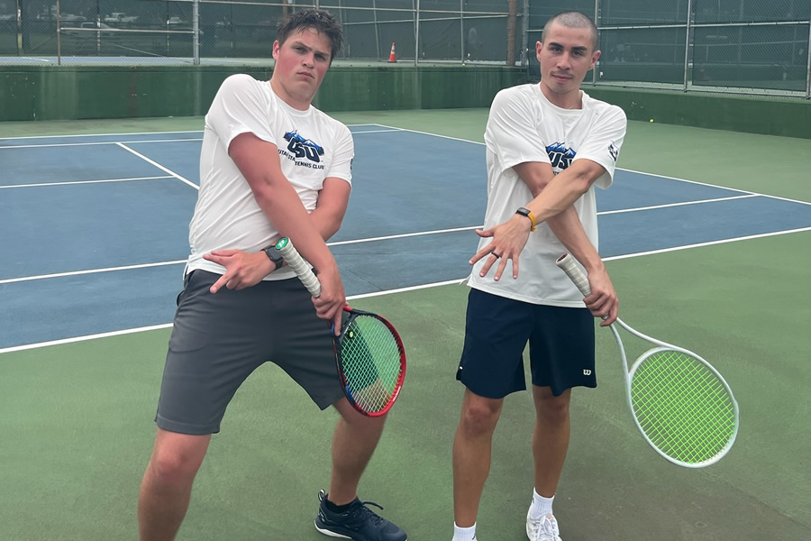 Two boys posing with tennis rackets
