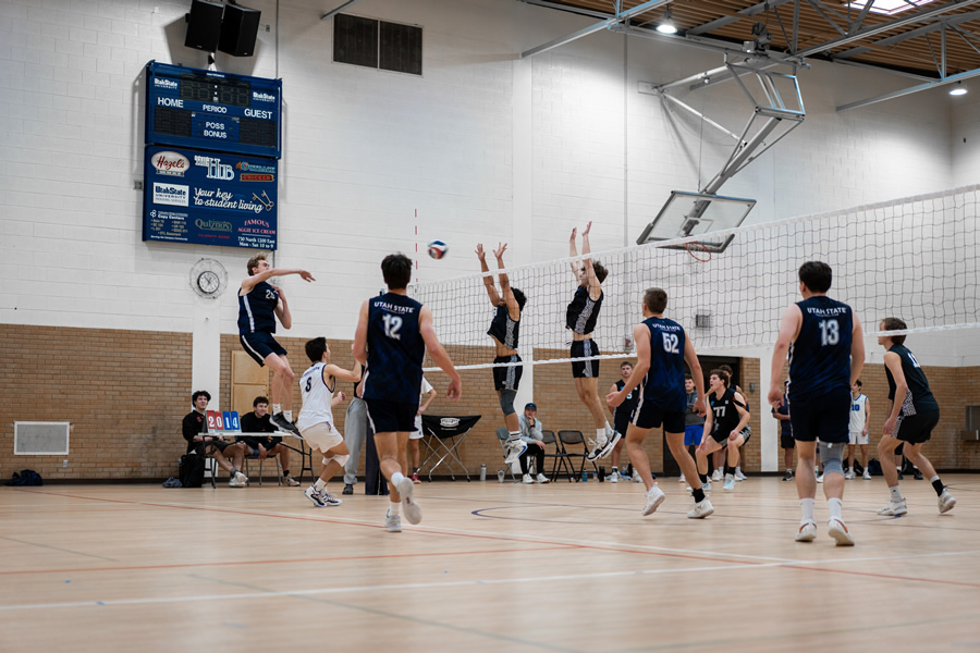 Two blockers jumping to try to stop a spike