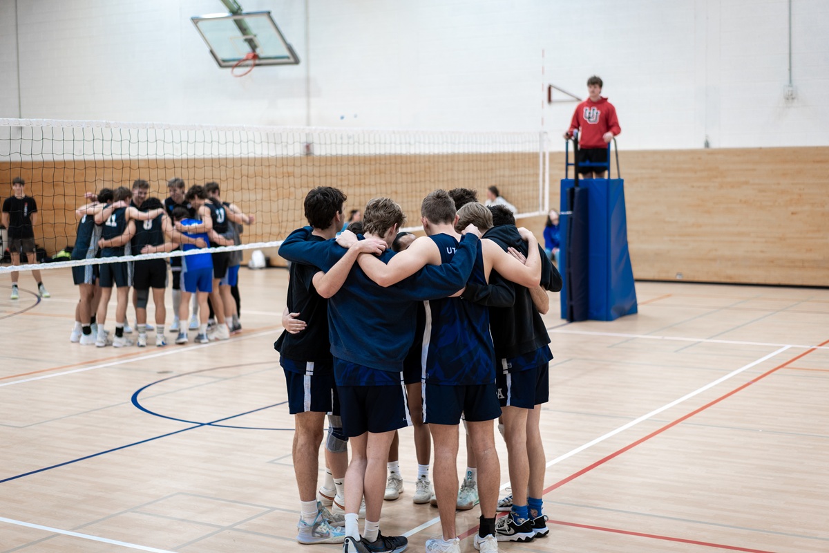 men's volleyball team huddle during a game