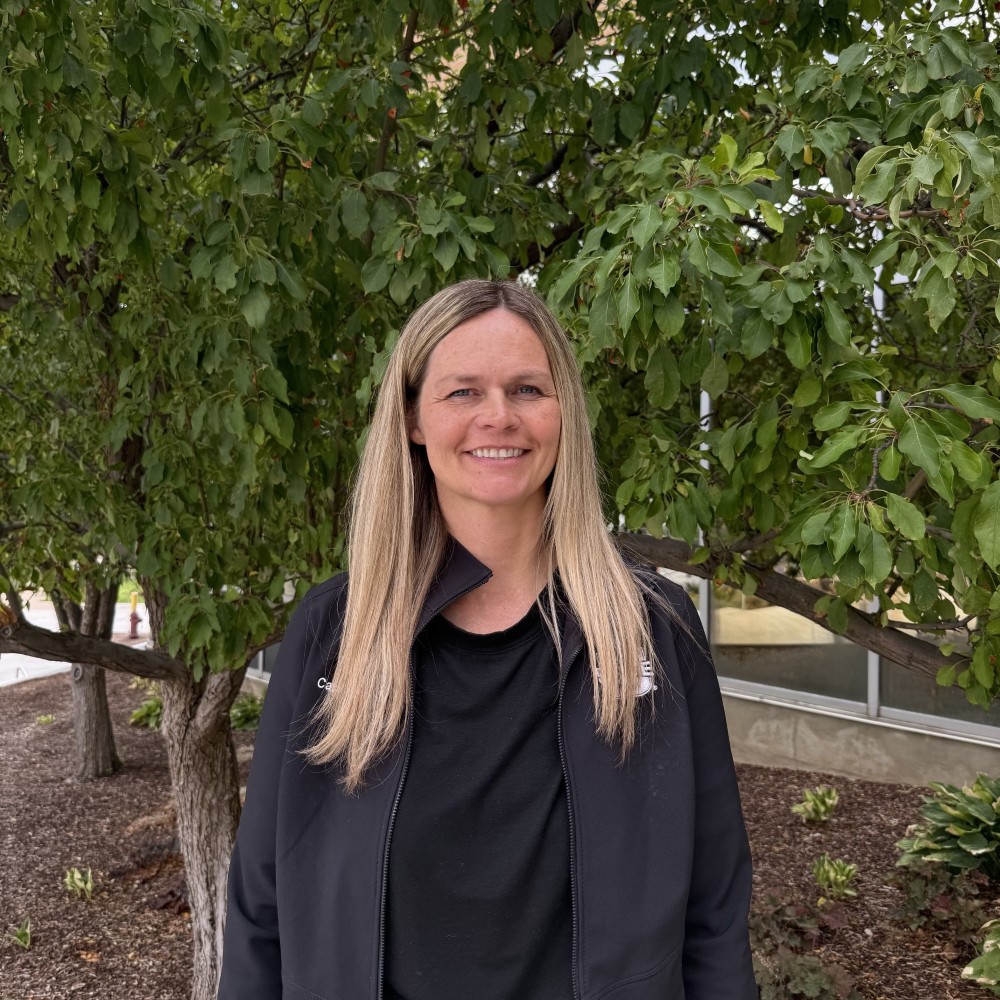Woman standing in front of a leafy tree