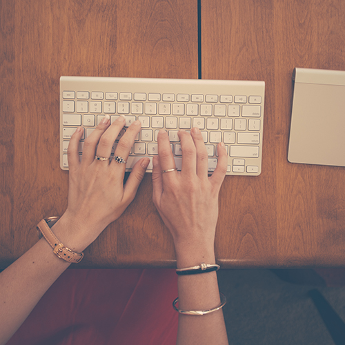 Womans hands on an Apple keyboard