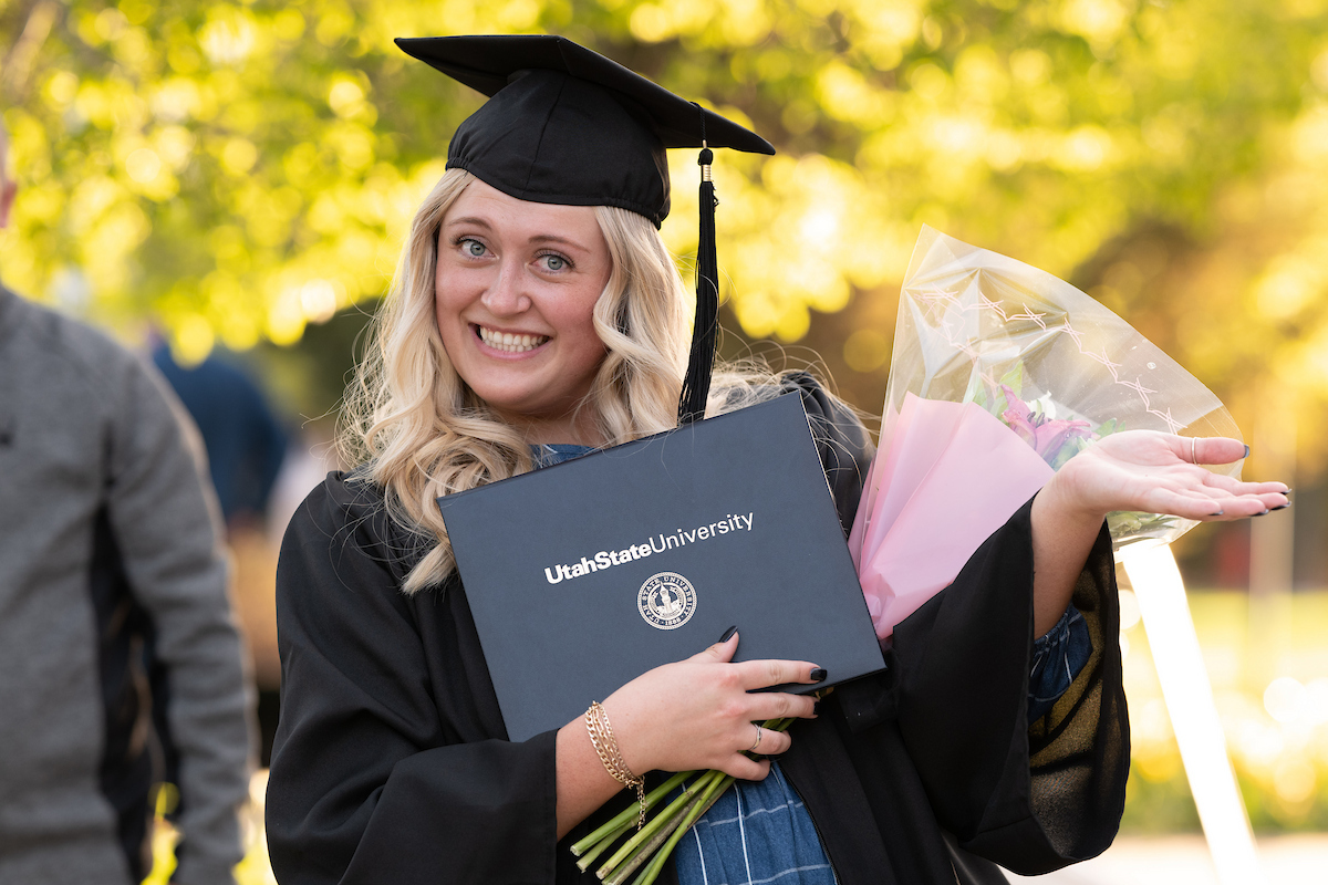 Graduate holding flowers