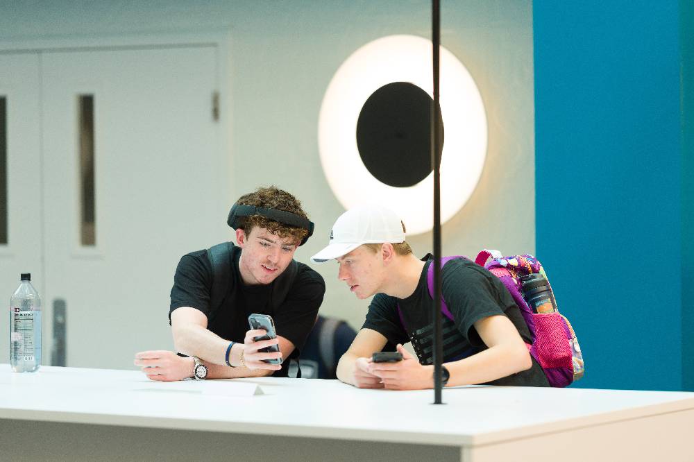 2 people at a table comparing notes on their phones