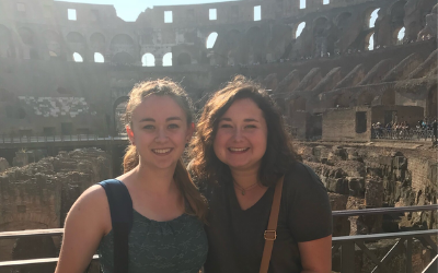 USU Alumnus Meg Rassmussen poses with another woman inside the Colosseum