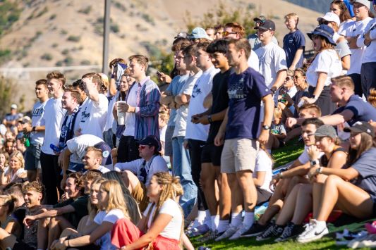 A diverse group of students standing and sitting on a grassy hill, facing forward, with a mountain in the background. This image links to the USUSA Applications page.