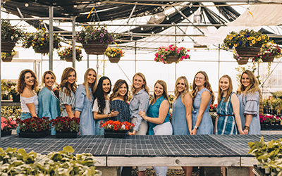 Sorority members at Utah State University pose for a picture at a flower shop.