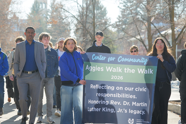group of students marching with a banner reading -Reflecting on our civic responsiibilites. Honoring Rev. Dr. Martion Luther King, Jr's legacy