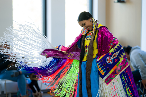 USU Native American Heritage event dancer dressed in vibrant colored native american dress