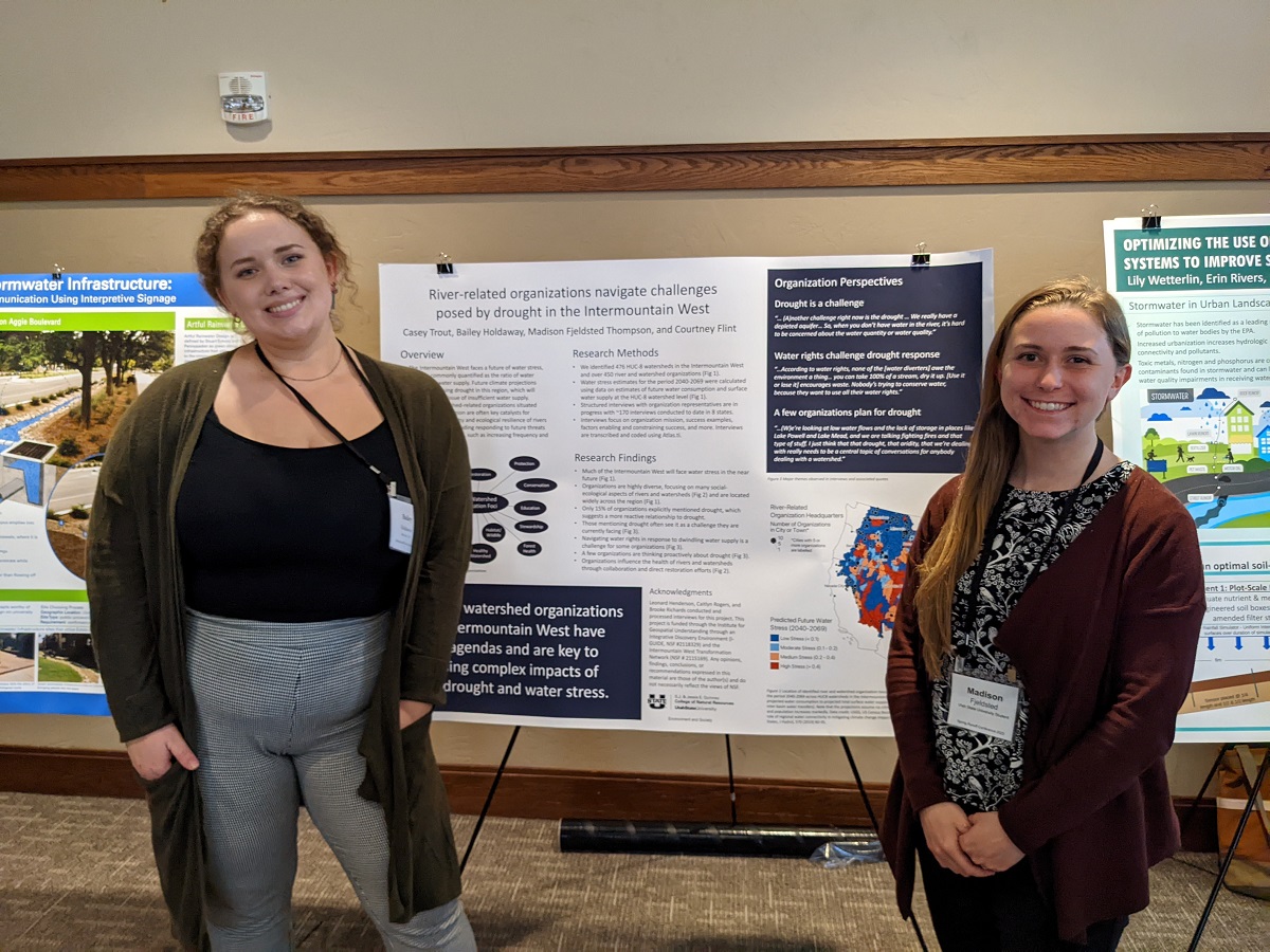 Bailey Holdaway and Madison Fjeldsted Thompson next to their poster about river organizations in the Intermountain West.