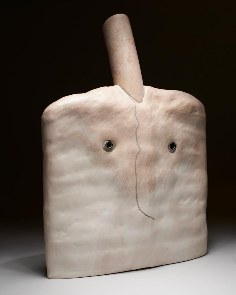 Flat oblong sculpture with two small holes and a cylindrical pipe rising from the top