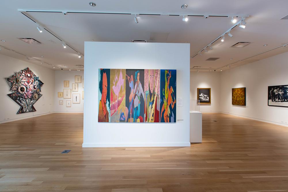 A central wall structure in the middle of a room with art hung around