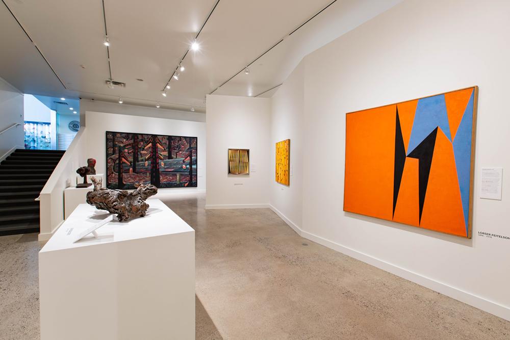 Stairs on the left and arts displayed in the adjacent space