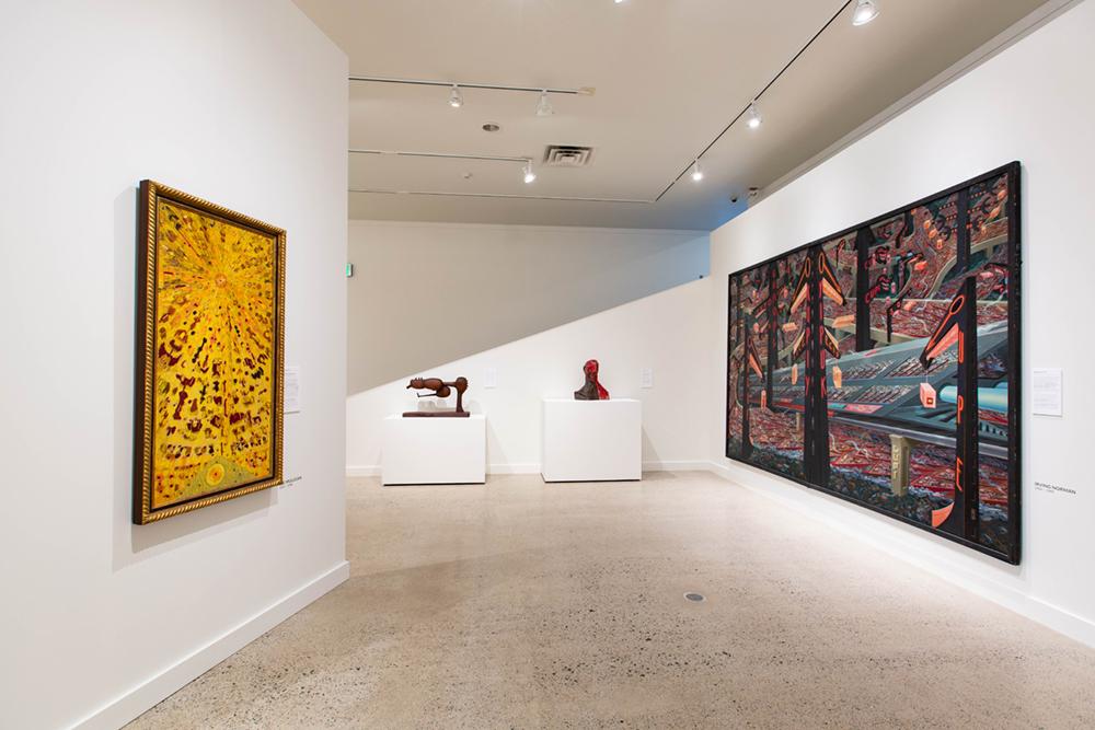Two very large art pieces hung on the side walls with two small sculptures in the back