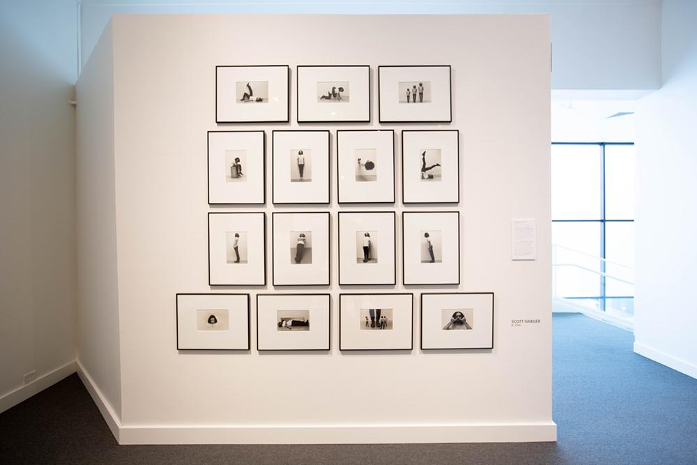 A gallery wall of various framed art of a human figure in different standing/sitting positions