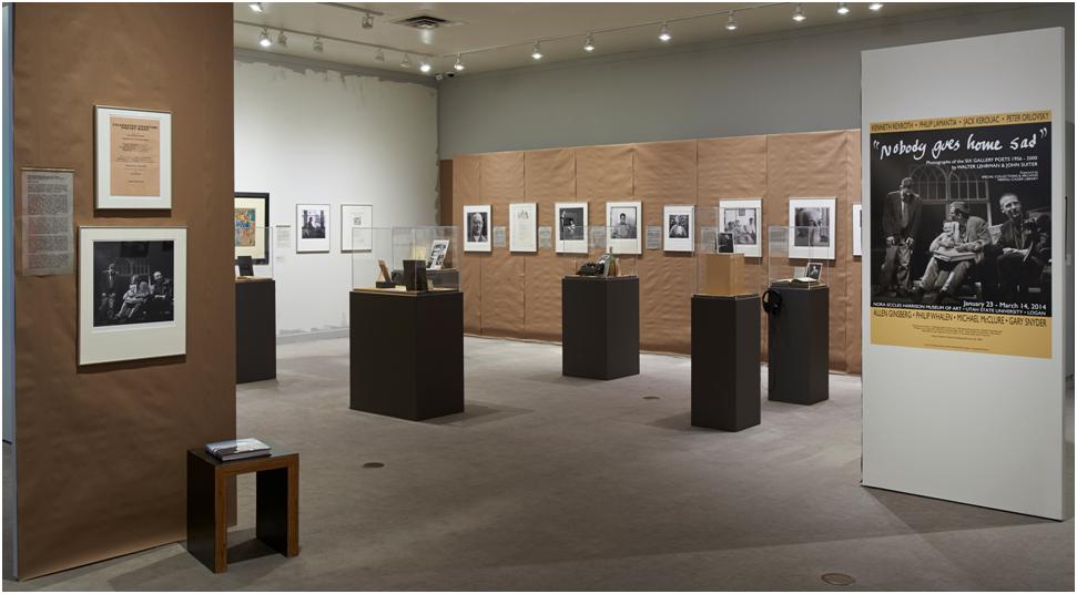 An exhibition space with brown walls and black display tables