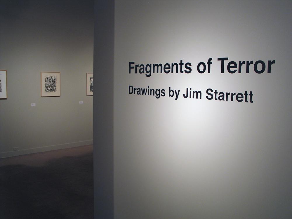 Gray introduction wall with the words "Fragments of Terror Drawing by Jim Starrett"