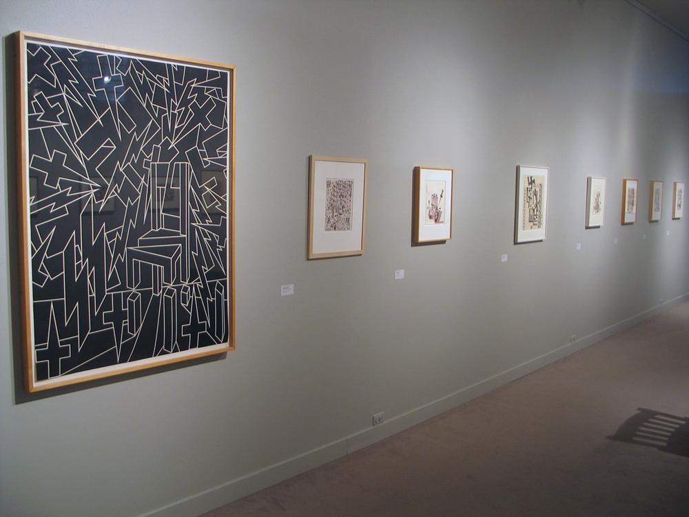 A gray wall with large and small framed art