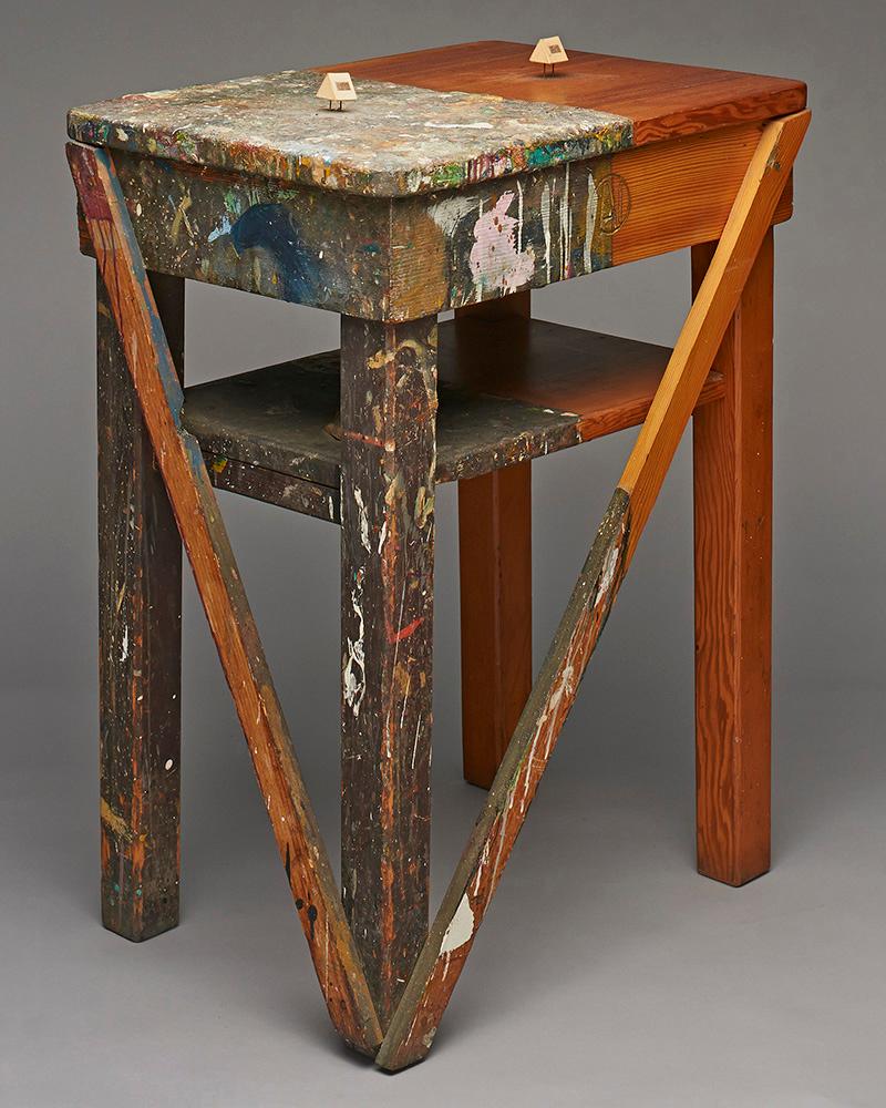 A wooden stool with half painted messily 