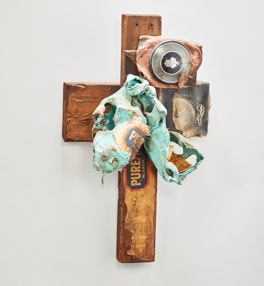 A wooden cross with things attached 