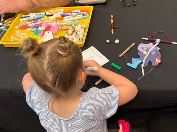 Toddler drawing with markers during Mini Makers class.