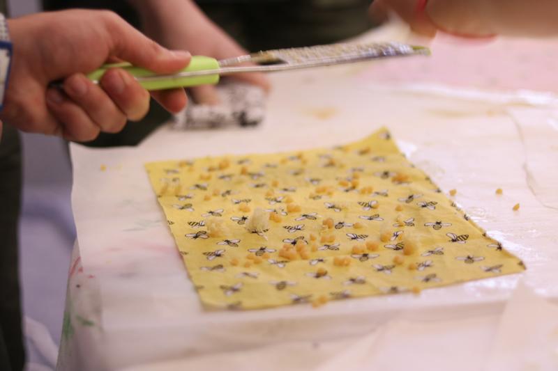 Grating beeswax onto fabric.