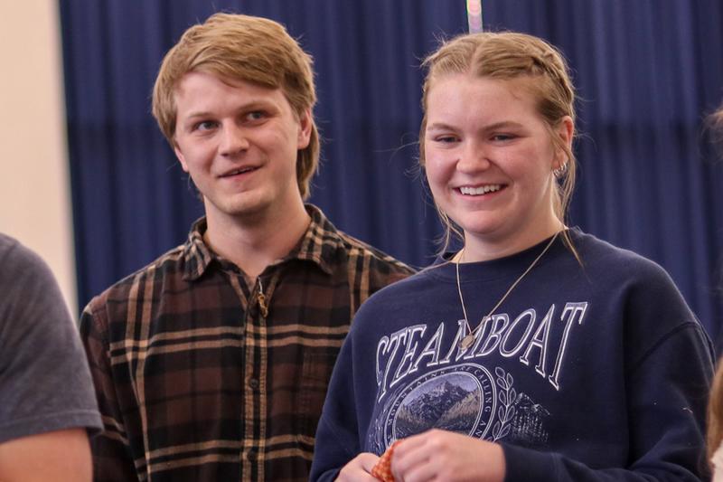 Two students standing near each other and smiling.