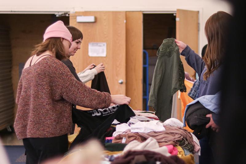 Students looking through clothes.
