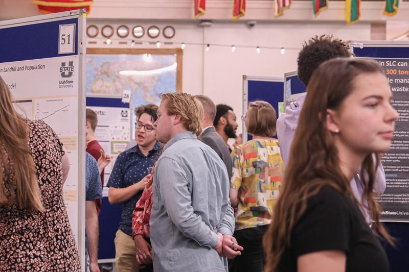 A group of people looking at various posters about various community-engaged work.