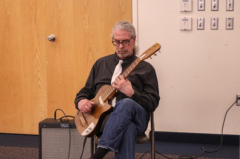 Local musician Todd Milovich playing guitar.