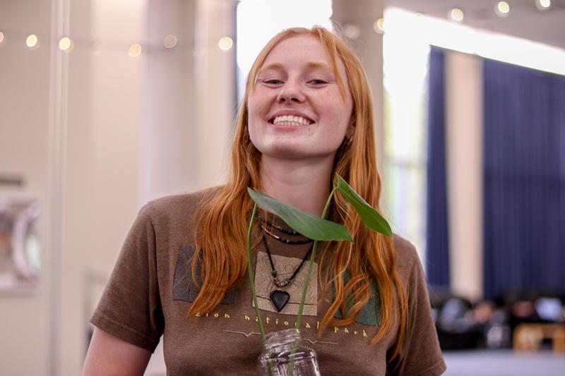 Student smiling with their new plant.