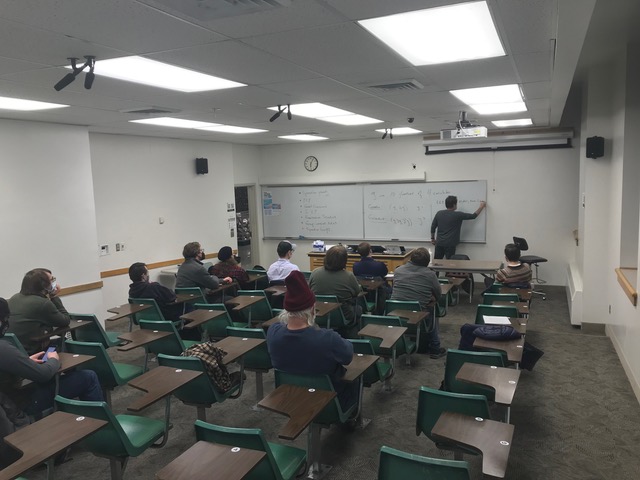 a man teaching general relativity mathematics to a classroom of grad students