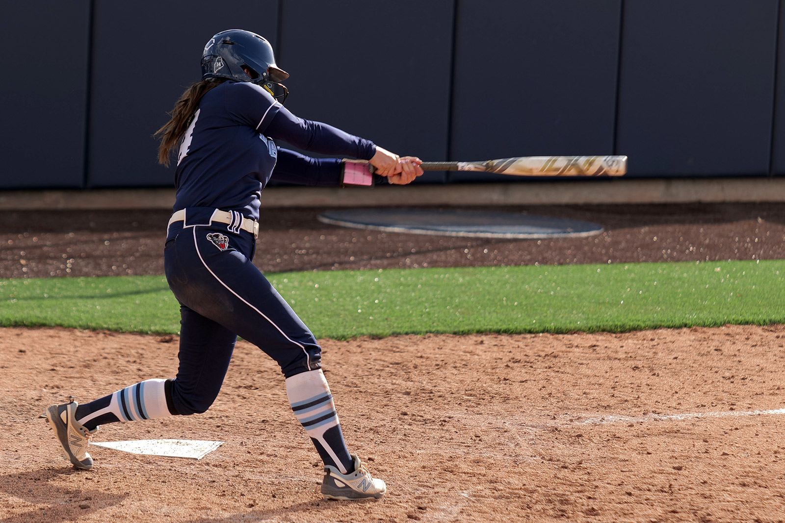 softball player swings her bat