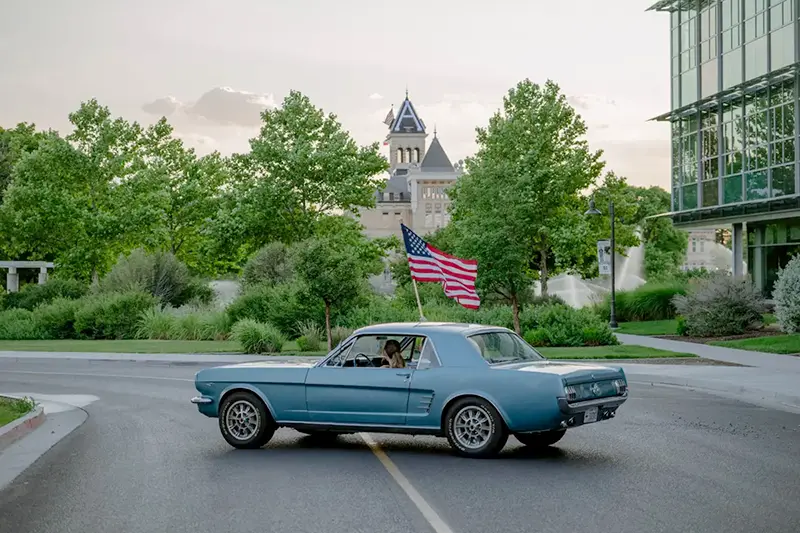 Old car on campus with Old Main in the background