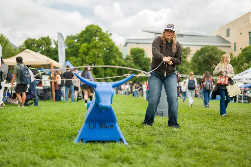 Student roping lil blue on the quad