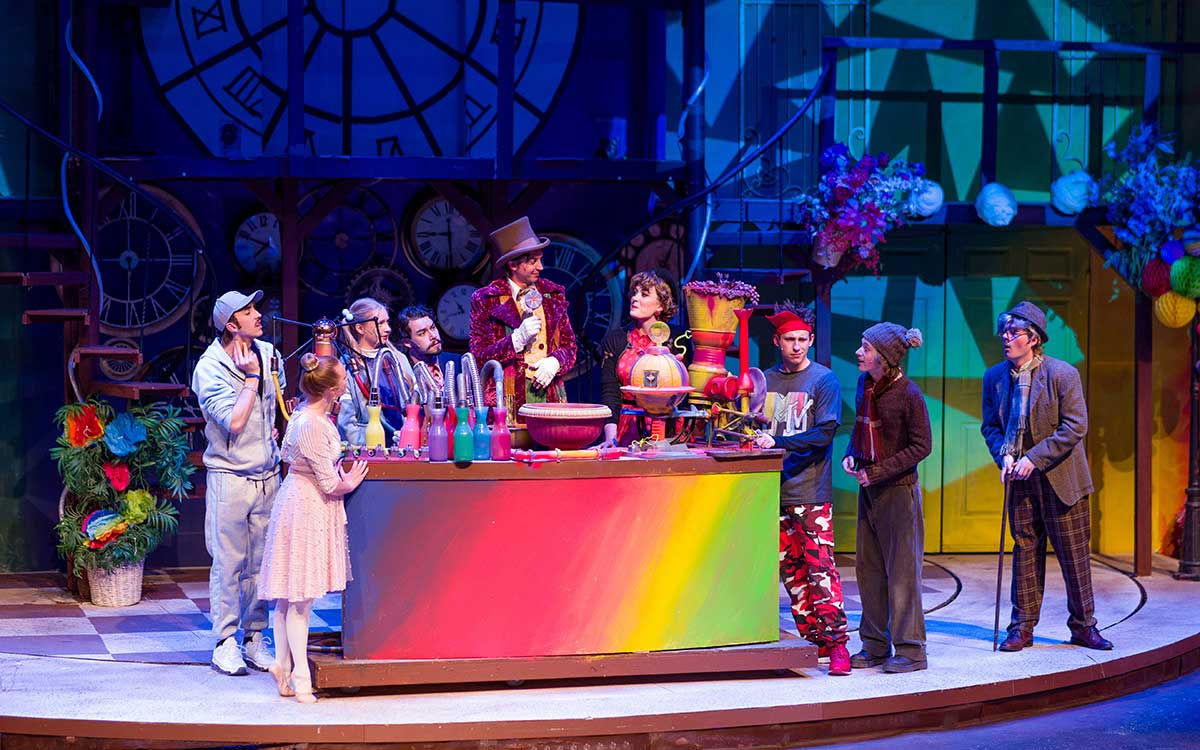 student production of Willy Wonka gathered around table