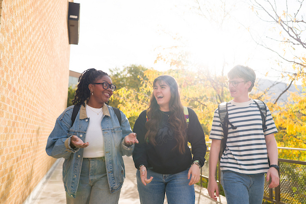 3 students walking on the sidewalk
