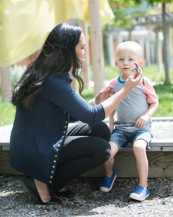 A female student helping a child with cochlear implants during class.