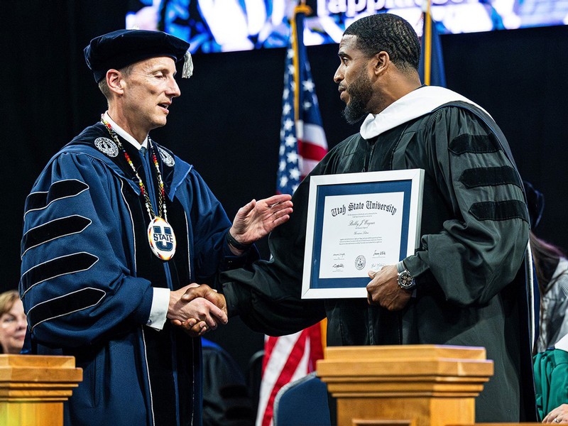 Bobby Wagner receives a diploma from Brad Mortensen.
