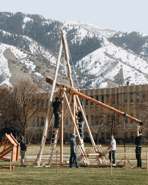A group of students constructing a trebuchet on the Quad.