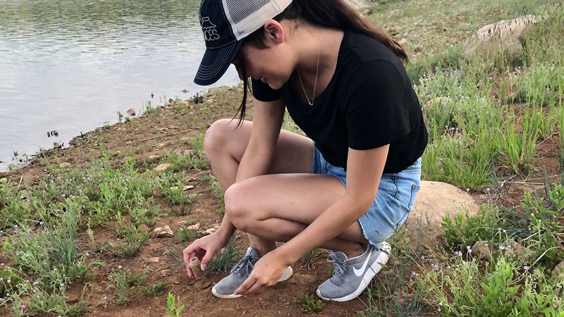 Student collects sand samples.