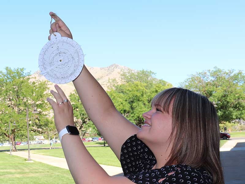 USU researcher holding an astrolabe.