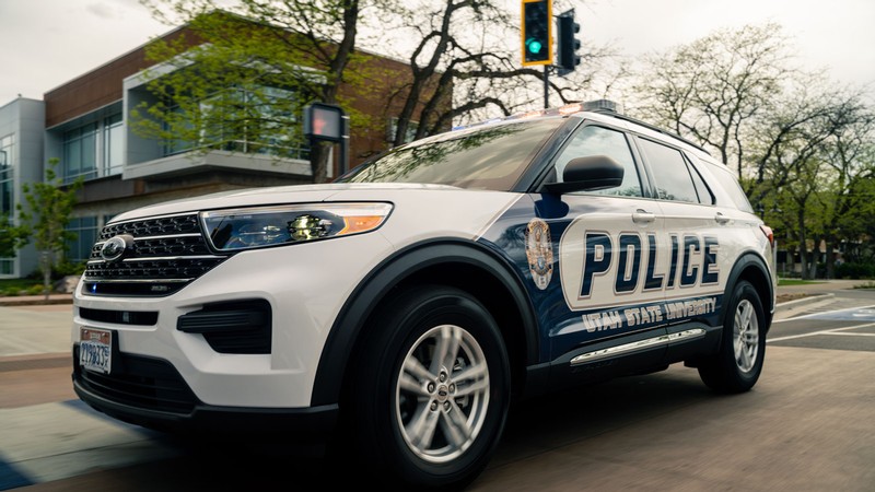 A Utah State University Police vehicle driving on Aggie Bull-evard.