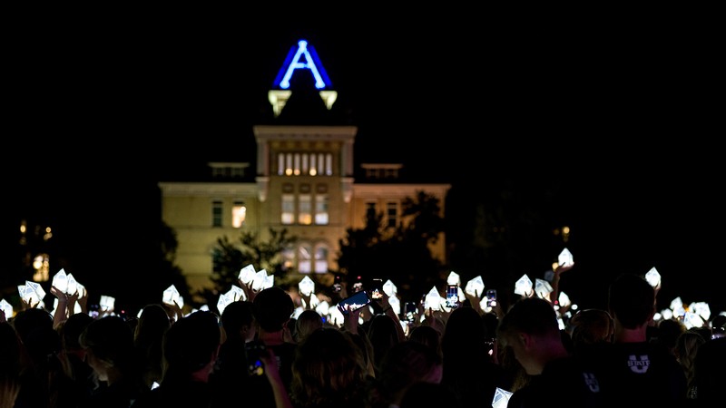 Students stand with lanterns lit celebrating first week of school