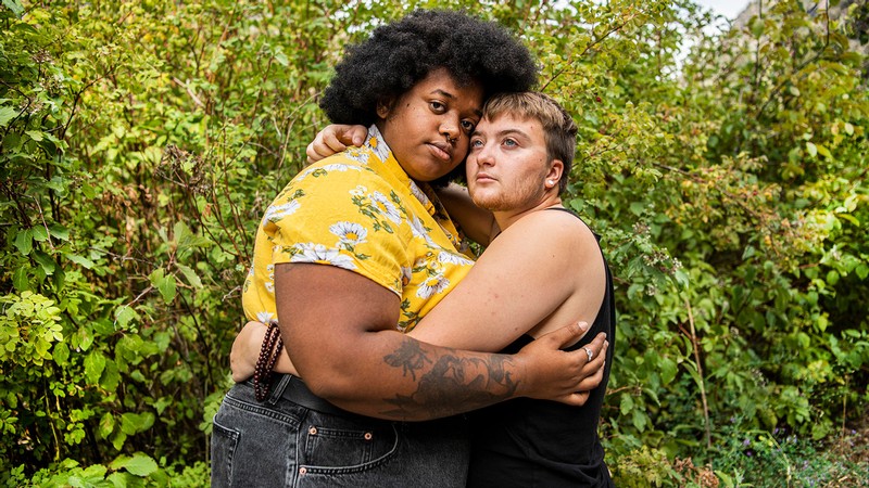 Two people embracing in the outdoors.