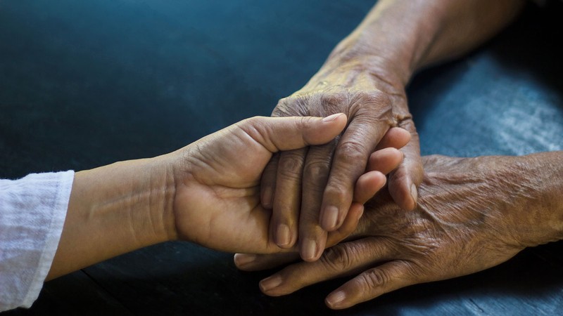 Two people hold hands.